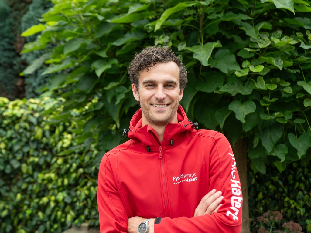 Rick van Eupen draagt een rode jas van Fysiotherapie Hatert Nijmegen